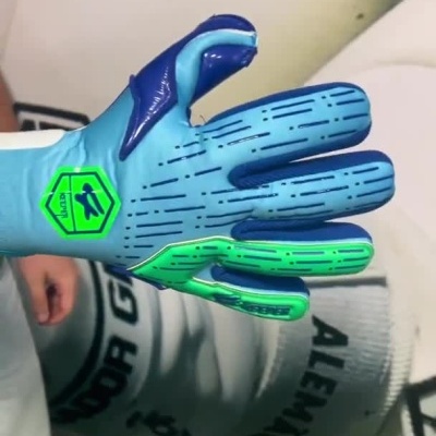 Pessoa a vestir luvas desportivas azuis com detalhes verdes e ajuste de velcro