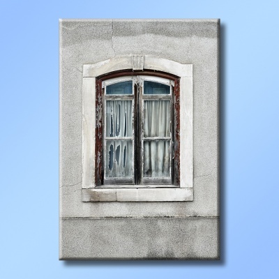 Janela antiga de madeira com cortinas brancas numa parede cinza