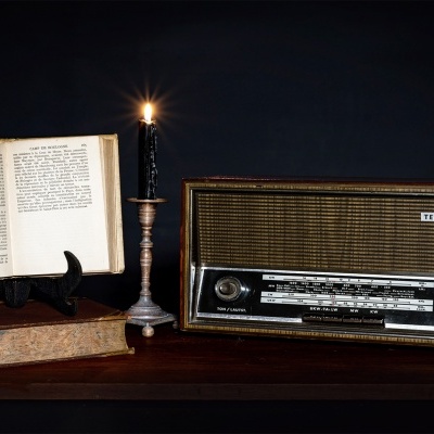 Rádio vintage Telefunken com livros antigos e castiçal com vela