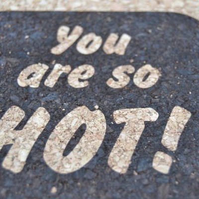 Suporte para copos de cortiça castanho com texto 'you are so HOT!' impresso em branco