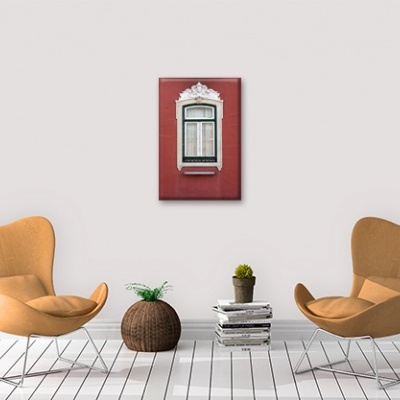 Duas cadeiras castanho claro, vaso com plantas, livros e fotografia de janela branca em fundo vermelho