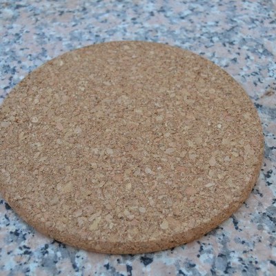 Tapete redondo de cortiça sobre superfície de pedra malhada cinza