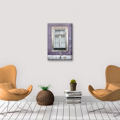 Sala com duas cadeiras laranja claro, vaso castanho com planta, pilha de livros e quadro de janela roxa antiga