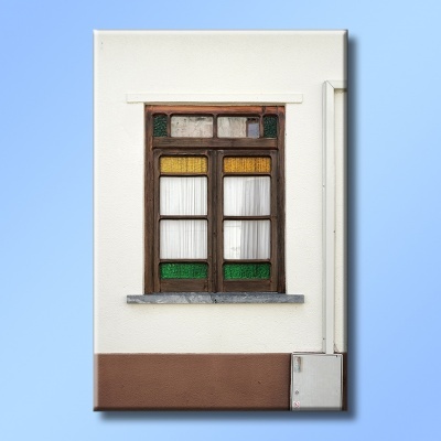 Janela de madeira com vidros coloridos numa parede branca com base castanha e quadro elétrico