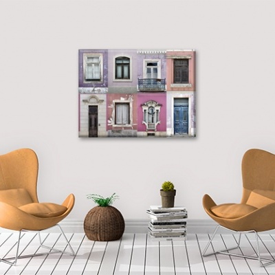 Sala moderna com duas poltronas castanhas, plantas e quadro com foto de fachadas coloridas