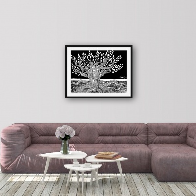 Sofá rosa aveludado com mesas brancas e quadro de árvore preto e branco na parede branca