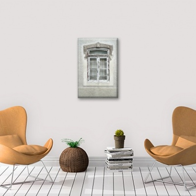 Dois cadeirões castanho claro com almofadas e quadro de janela antiga cinzenta na parede branca