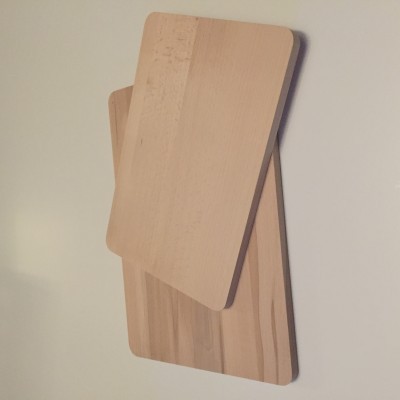 Duas tábuas de corte retangulares de madeira clara sobre superfície branca