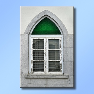 Janela de madeira branca com vitral verde e moldura de pedra cinzenta