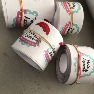 Rolos de etiquetas adesivas brancas com texto 'Ponto de Açúcar' e desenhos coloridos