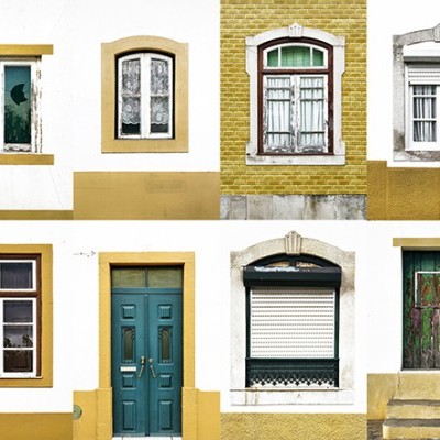 Parede com sete janelas e uma porta de estilos variados, em branco, amarelo, verde e madeira.