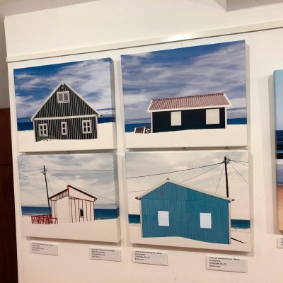 Quadros de casas costeiras em galeria de arte