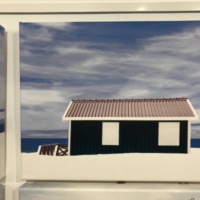 Tela decorativa com imagem de casa preta à beira-mar