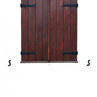 Janela com portas de madeira castanha, dobradiças pretas, parede branca e faixa castanho avermelhado.