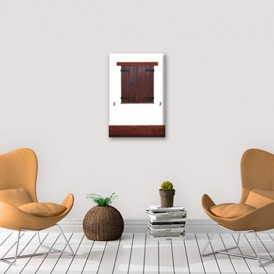 Duas cadeiras castanhas claras em sala branca com mesa, plantas e quadro com porta de madeira.