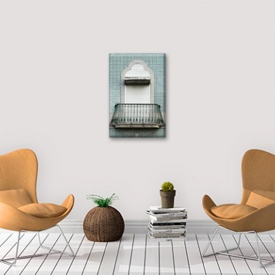 Sala com duas cadeiras castanhas claras, puff e quadro na parede