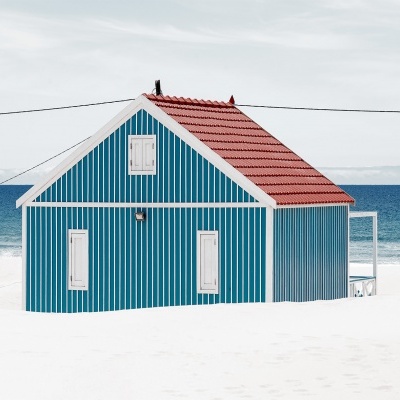 Casa de praia azul com telhado vermelho e detalhes brancos em fundo de praia e mar