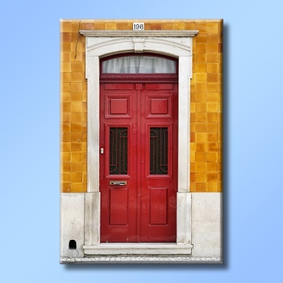 Porta vermelha dupla com moldura de pedra e azulejos amarelos à volta