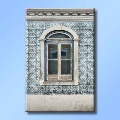 Janela antiga em parede de azulejos tradicionais portugueses azuis com padrão geométrico e moldura branca