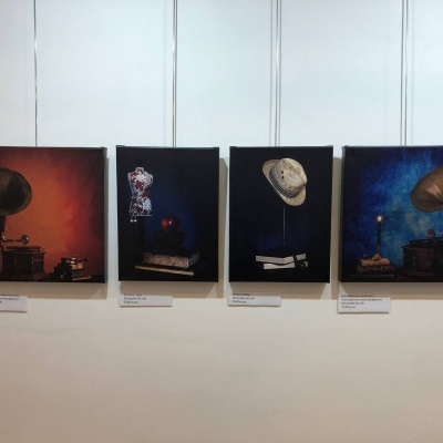 Quatro quadros com temas vintage pendurados numa parede branca.