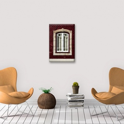 Sala com duas cadeiras cor camel, cesto, livros e quadro decorativo