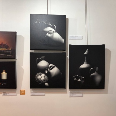 Quadros com pinturas de jarros e objectos em fundo escuro na parede branca