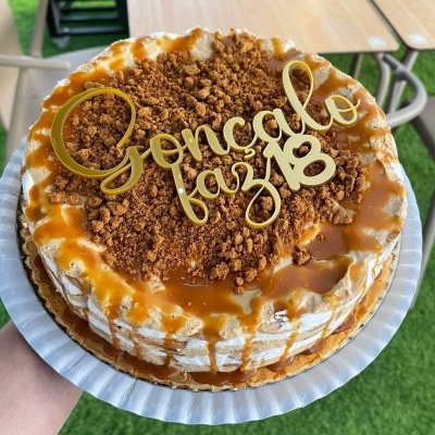 Bolo decorado com creme e caramelo com topo dourado 'Gonçalo faz 18'