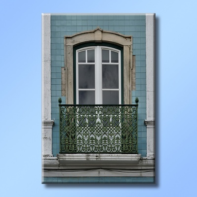 Janela branca de madeira com grade de ferro verde e azulejos azuis