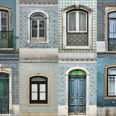 Diferentes janelas e portas em fachadas de azulejos azuis e brancos com grades de ferro forjado.