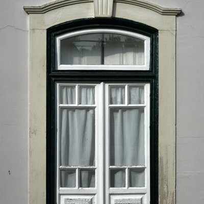 Janela de madeira branca e preta com cortinas brancas e moldura de pedra clara