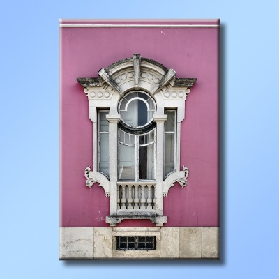 Janela ornamentada com moldura branca numa parede rosa