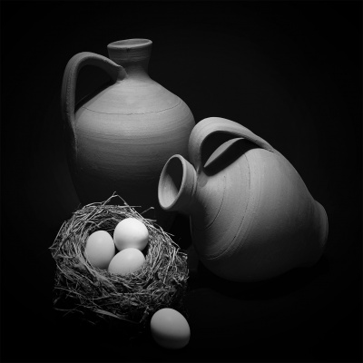 Dois cântaros de cerâmica com ninho e ovos brancos