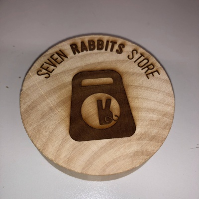 Disco redondo de madeira clara gravado com texto e logótipo