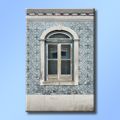 Janela antiga em parede de azulejos tradicionais portugueses azuis com padrão geométrico e moldura branca