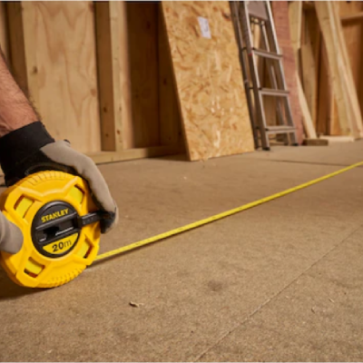 Medidor de fita métrica amarelo STANLEY 20m em ambiente de construção
