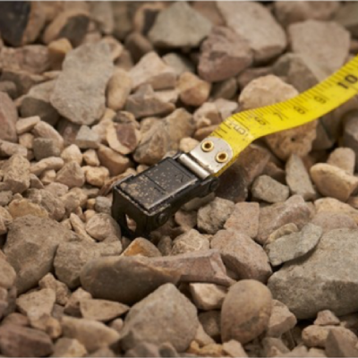 Fita métrica amarela sobre pedras