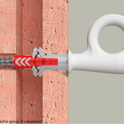 Ancoragem de parede em plástico cinzento e vermelho com parafuso metálico numa parede de tijolo vermelho