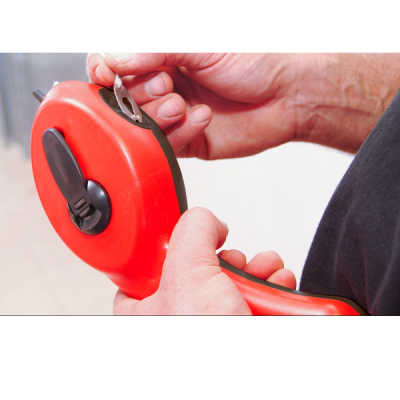 Trena vermelha com fecho preto segurada por duas mãos