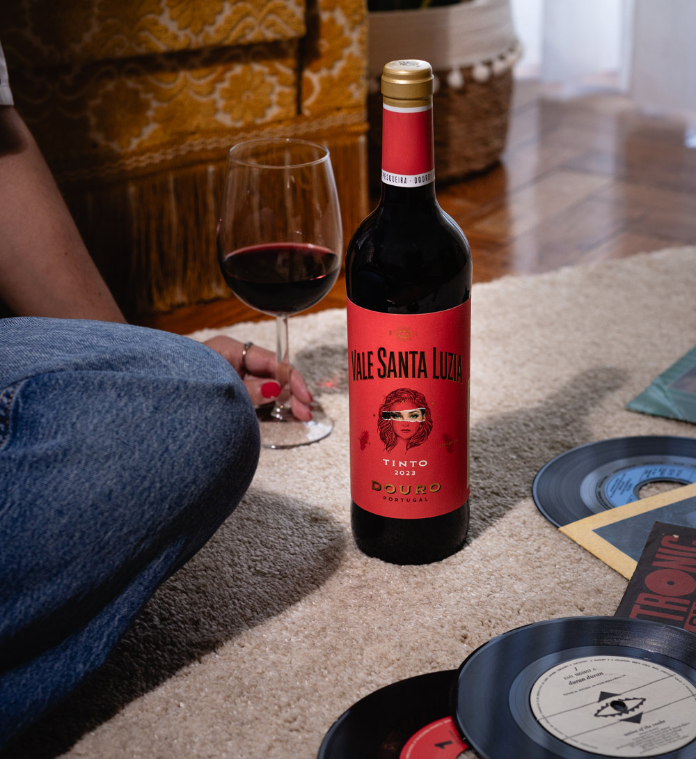 Vale Santa Luzia Tinto 2023 Garrafa de vinho tinto Vale Santa Luzia 2023 junto a taça e discos de vinil no chão