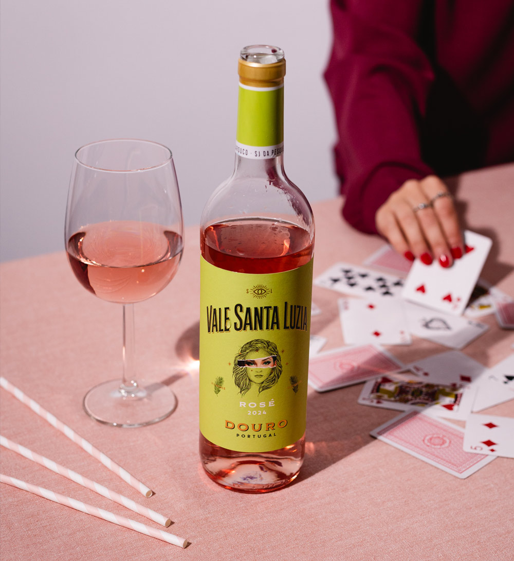 Vale Santa Luzia Rosé 2024 Garrafa de vinho rosé Vale Santa Luzia com copo e cartas de baralho num pano rosa