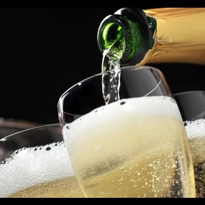 Copo de champanhe a ser preenchido com líquido espumante dourado.