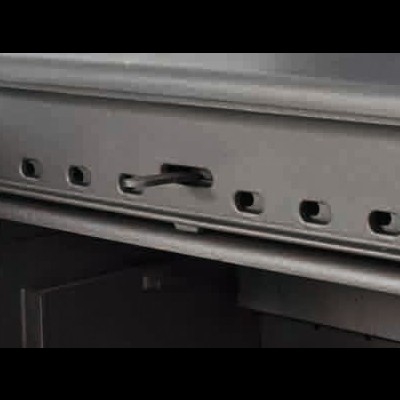 Fecho metálico cinza com alavanca e múltiplos orifícios numa superfície metálica.