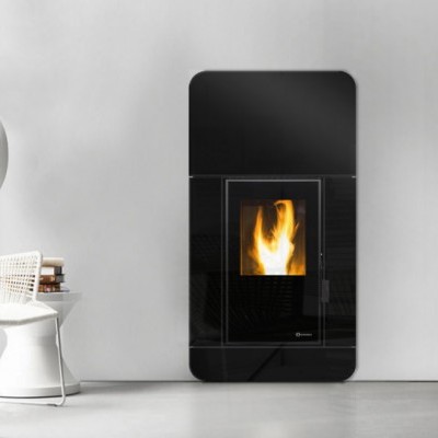 Lareira preta moderna com cadeira branca, mesa, candeeiros e pilhas de livros numa sala minimalista