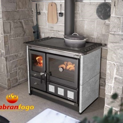 Fogão em ferro fundido com revestimento cinza claro entre paredes de pedra