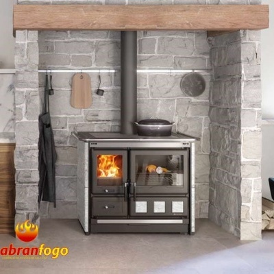 Fogão a lenha cinzento com forno de vidro numa estrutura de pedra cinzenta