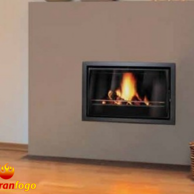 Lareira embutida com fogo aceso numa parede cinza