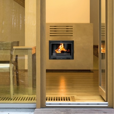 Lareira embutida numa parede bege numa sala com parquet e móveis de madeira