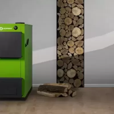 Caldeira verde e preta com pilha de troncos de madeira junto a parede cinzenta com padrão ondulado