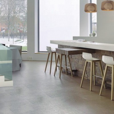 Lareira moderna branca com frontal preto e vidro, junto a balcão com bancos altos de madeira clara e assentos brancos