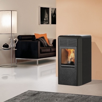 Lareira a pellets preta numa sala moderna com sofá e candeeiro